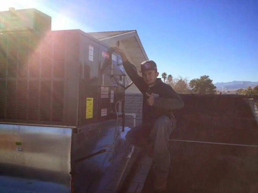 HVAC technician performing AC Tune-Up on a rooftop unit in Pahokee